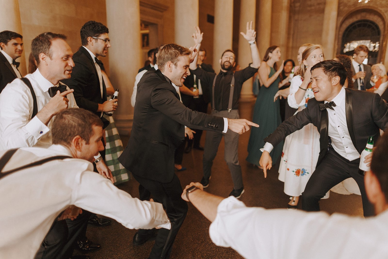 groom and friends in tuxes dancing at wedding