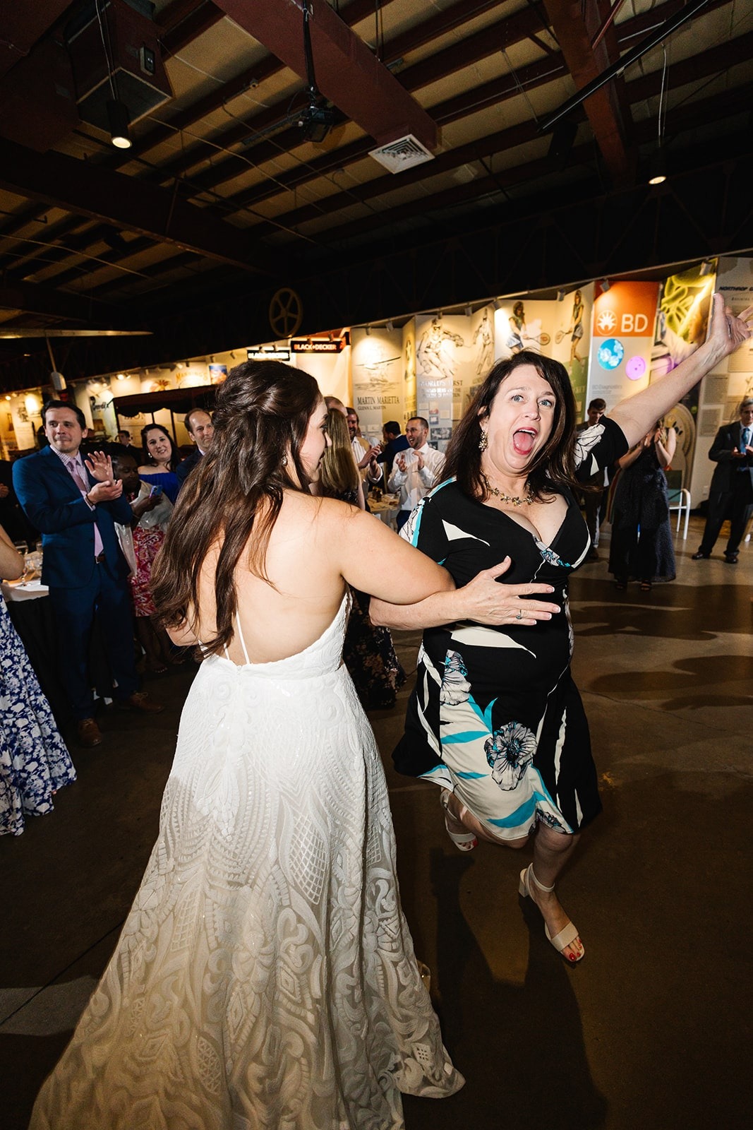 bride and woman dance arm in arm