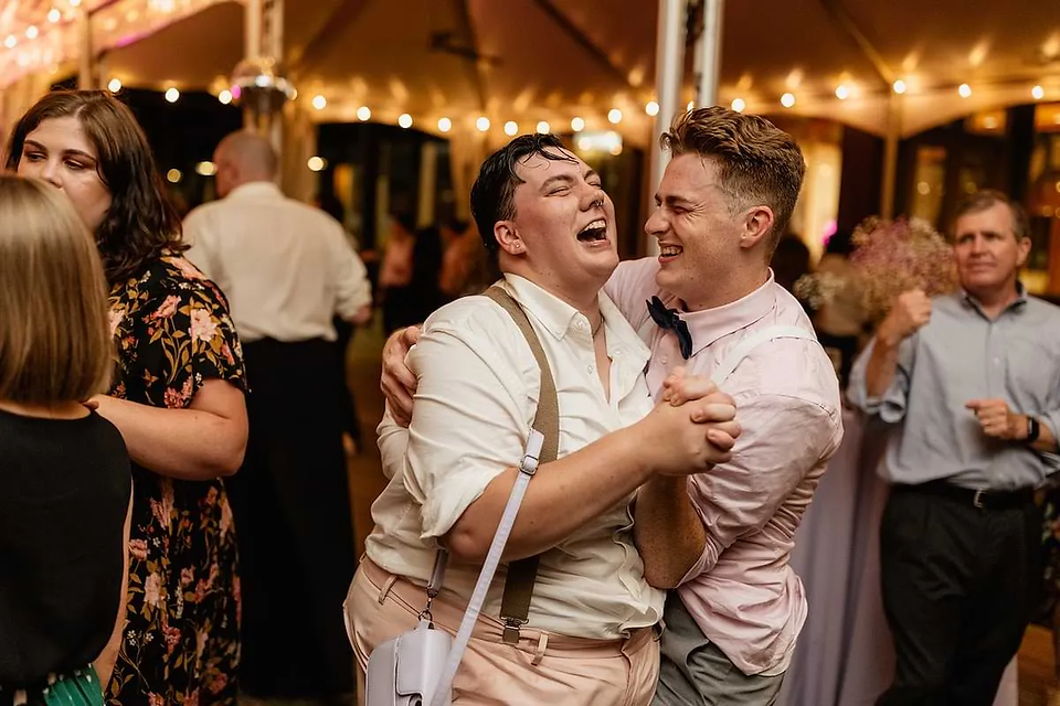 two guests slow dancing and laughing together