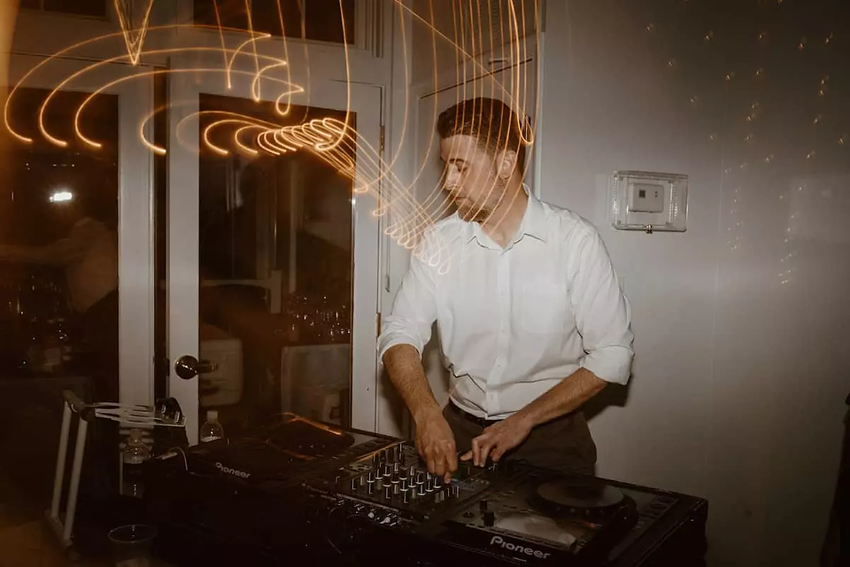 dj in white dress shirt mixing music at wedding