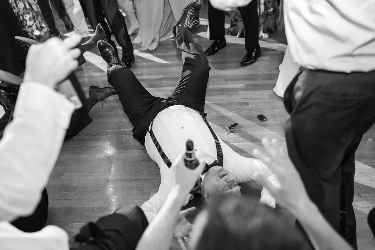 guy laying on floor dancing at wedding