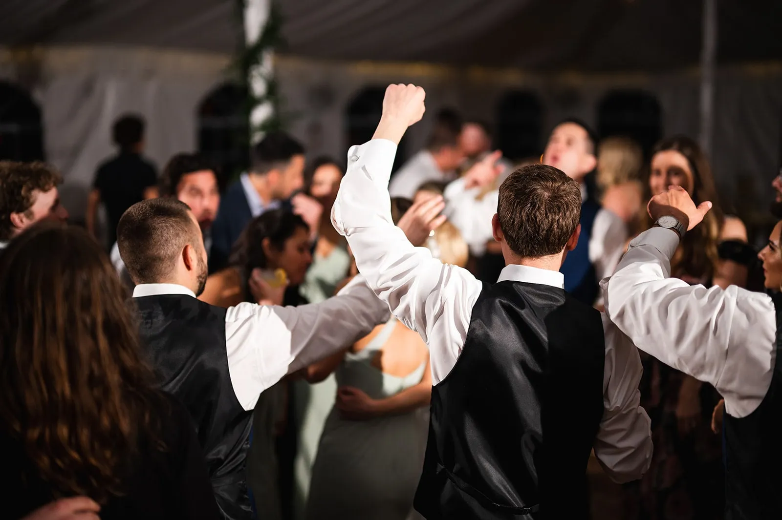 guys dancing with arms up at wedding