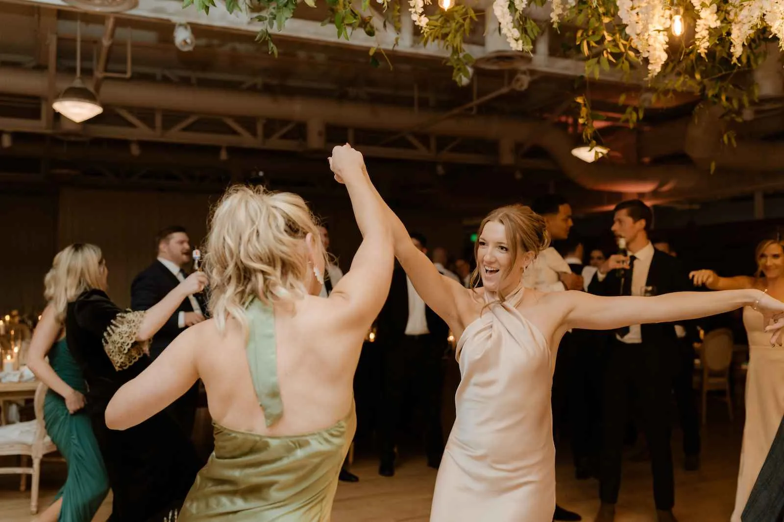 woman and bridesmaid dancing at wedding