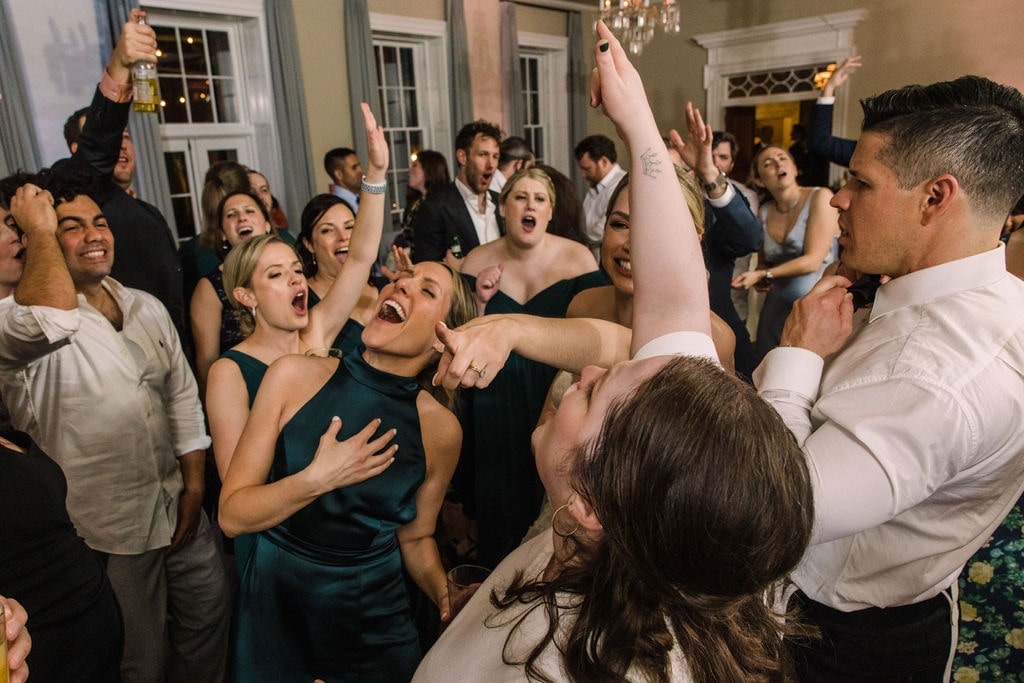 guests dancing and singing at wedding