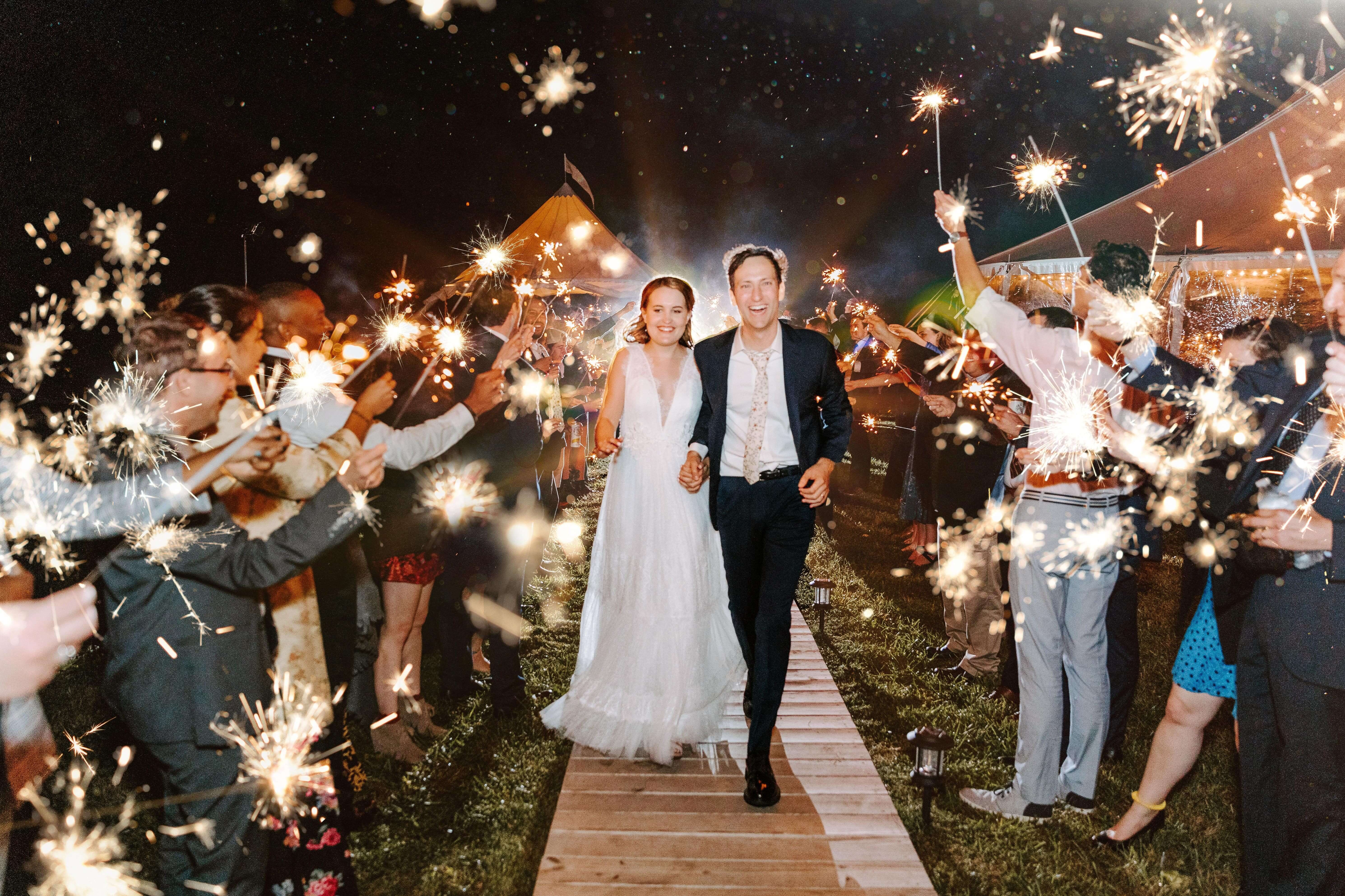 bride and groom walking down wooden path during sparkler exit
