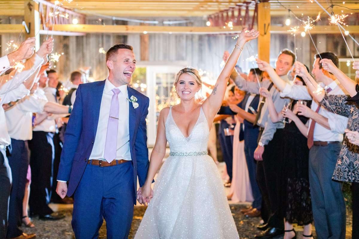 bride and groom smile during sparkler exit