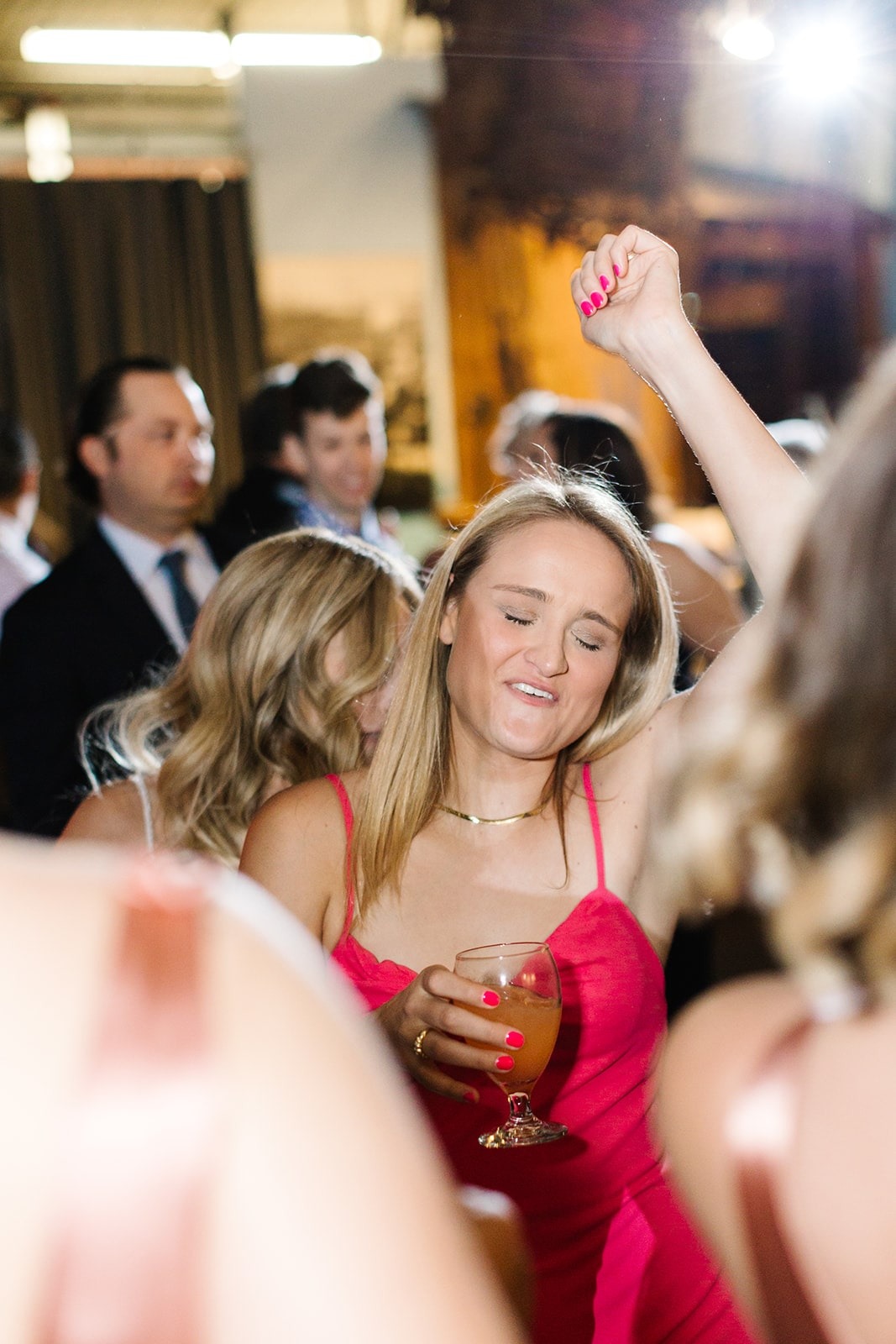 woman in pink dress dancing with hand up
