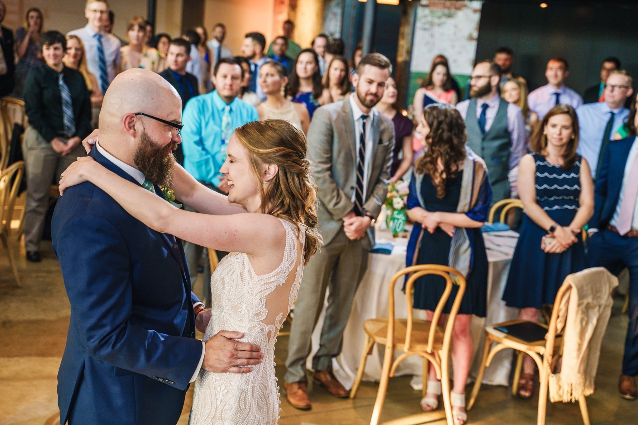 bride and groom first dance while guests watch from their tables