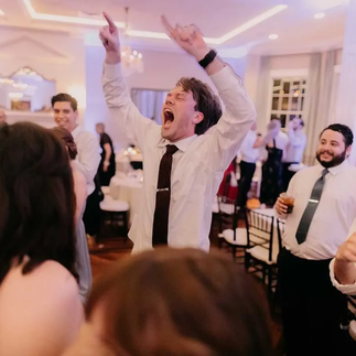 guy dancing with hands raised at wedding