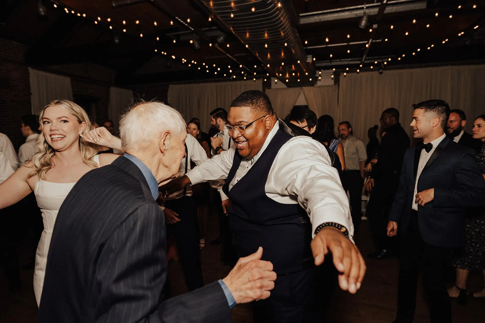 black man and old white man dance next to bride