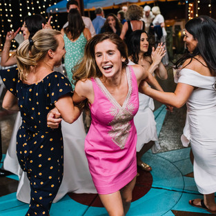 girl in pink dress spins other women at wedding