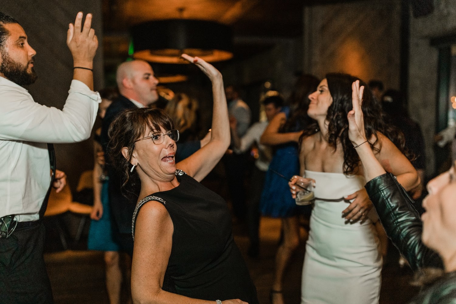 woman in black dress dancing with bride