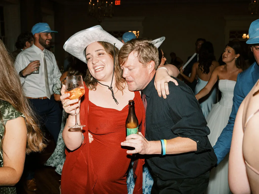 woman in red dress and cowboy hat dancing with man in black shirt 