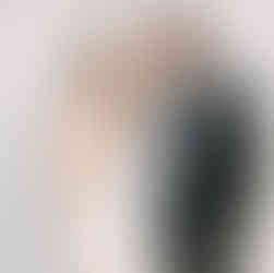 bride and groom pose in front of white brick wall