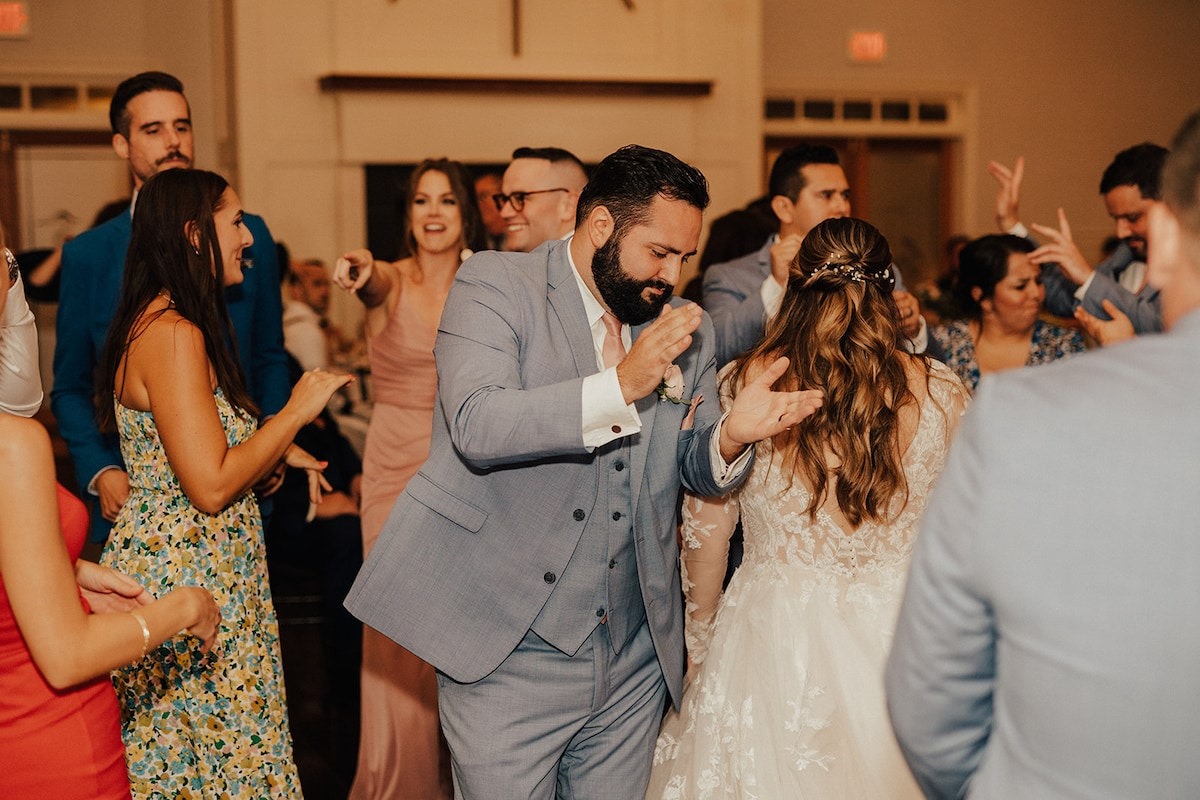 groom clapping while dancing at wedding