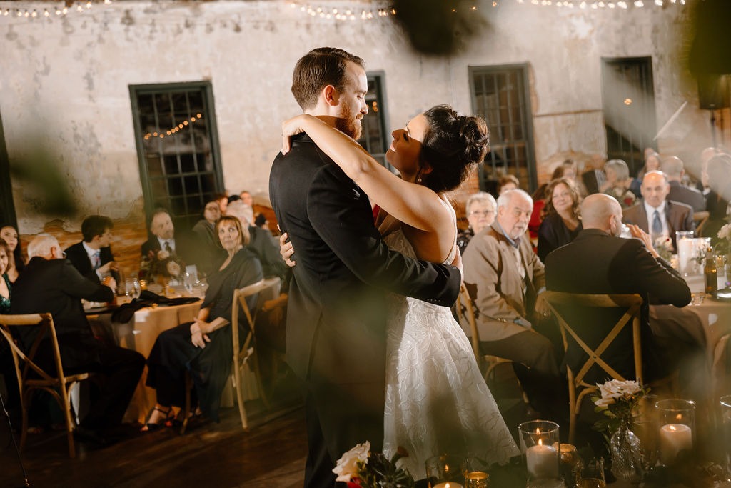 bride and groom dancing first dance while guests watch from their seats