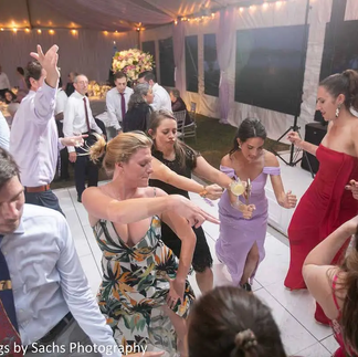 women and men dancing at wedding in tent