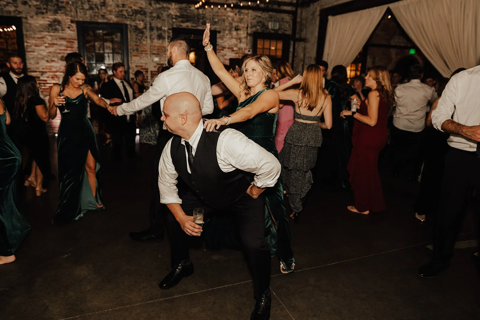 guy dancing low in front of woman at wedding