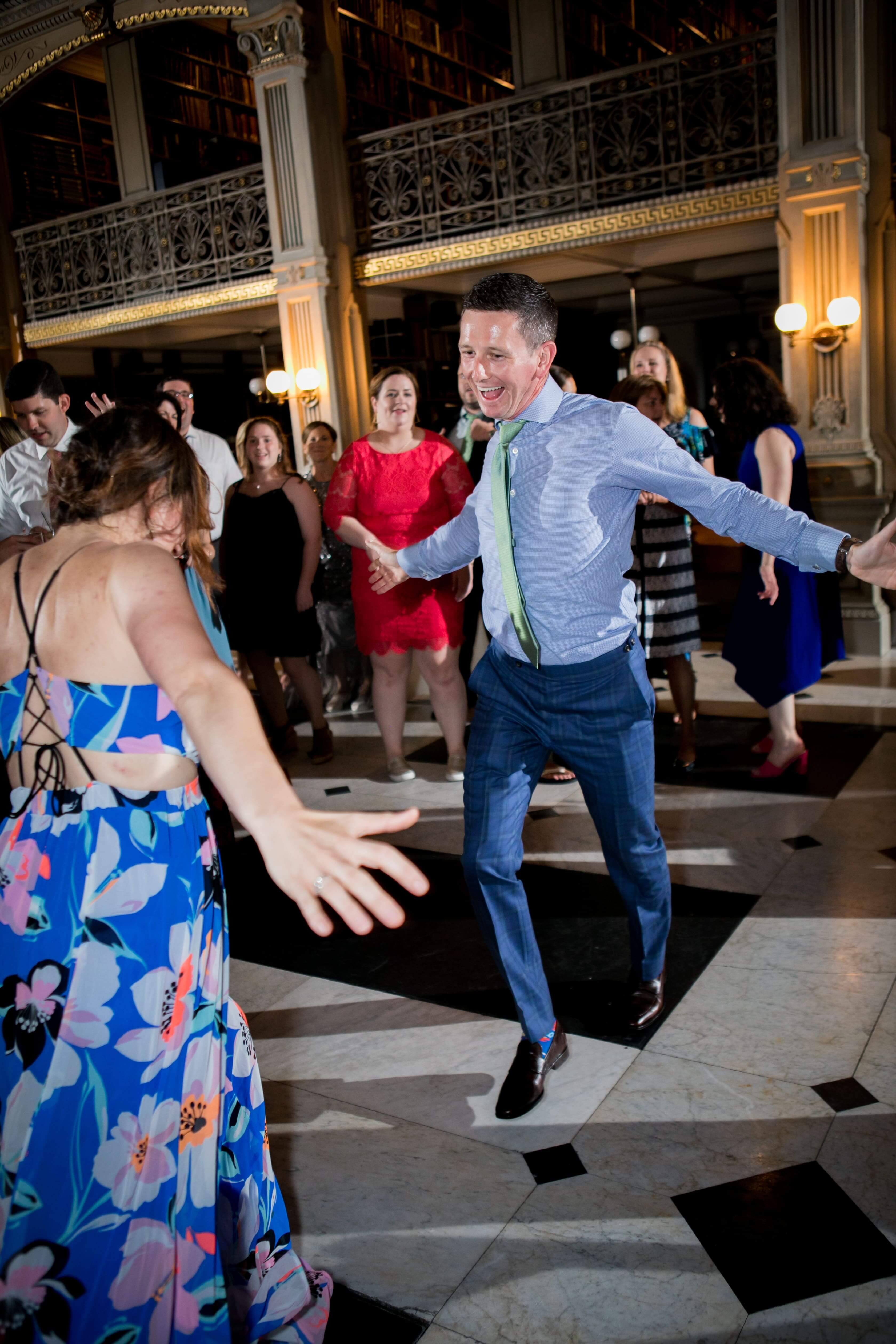 woman and man in blue pants and shirt dancing at a wedding