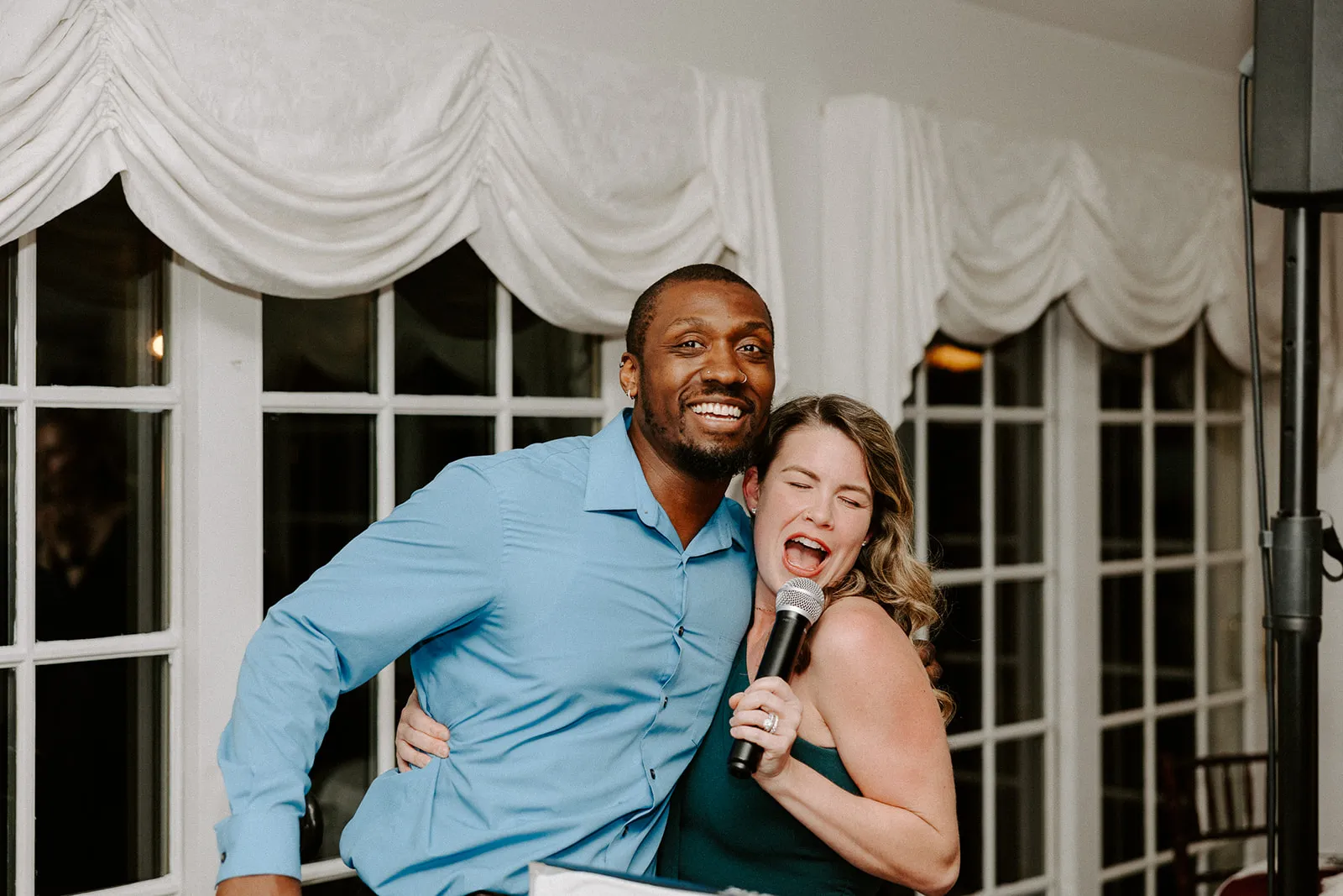 dj smiling with guest singing into mic