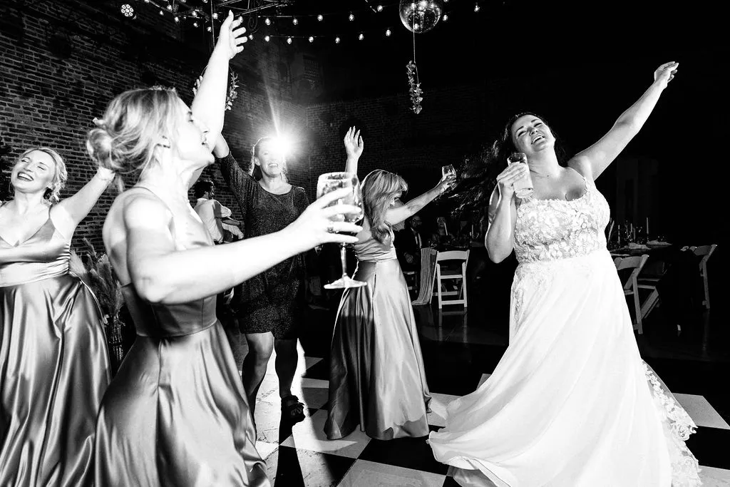 bride and women dancing with hands up