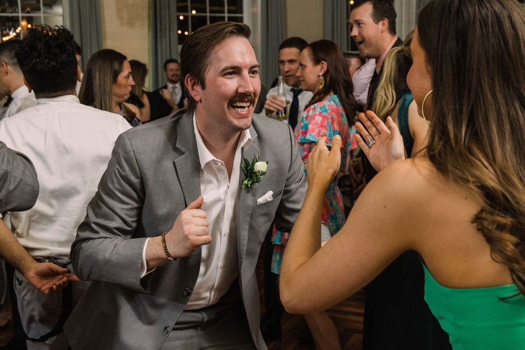 guy in grey suit dancing at wedding with woman