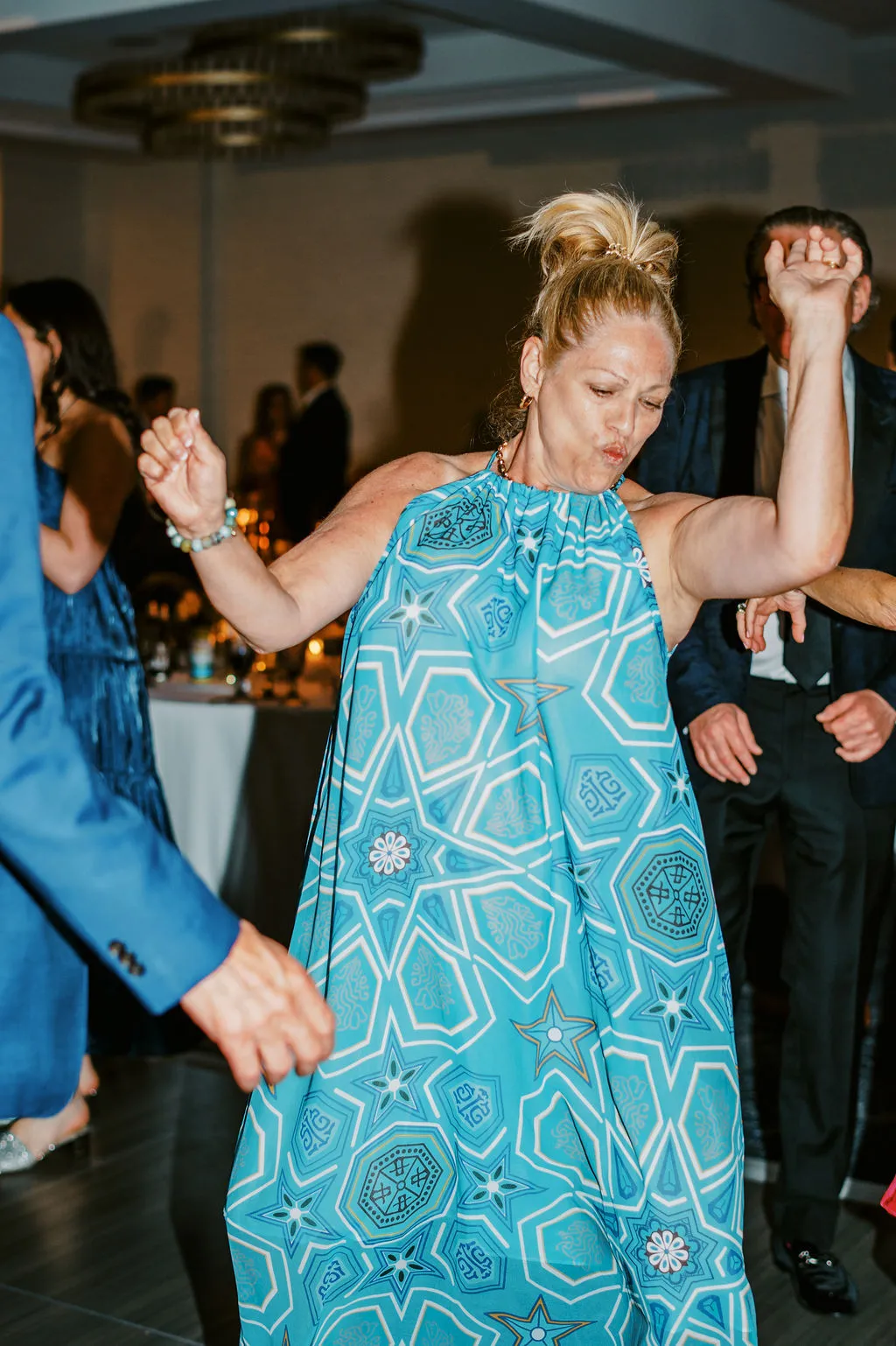 woman in blue loose dress dancing at wedding