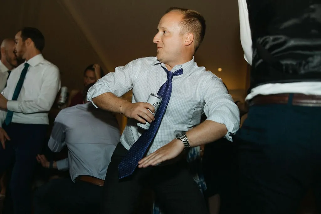 guy dancing at wedding with seltzer in hand