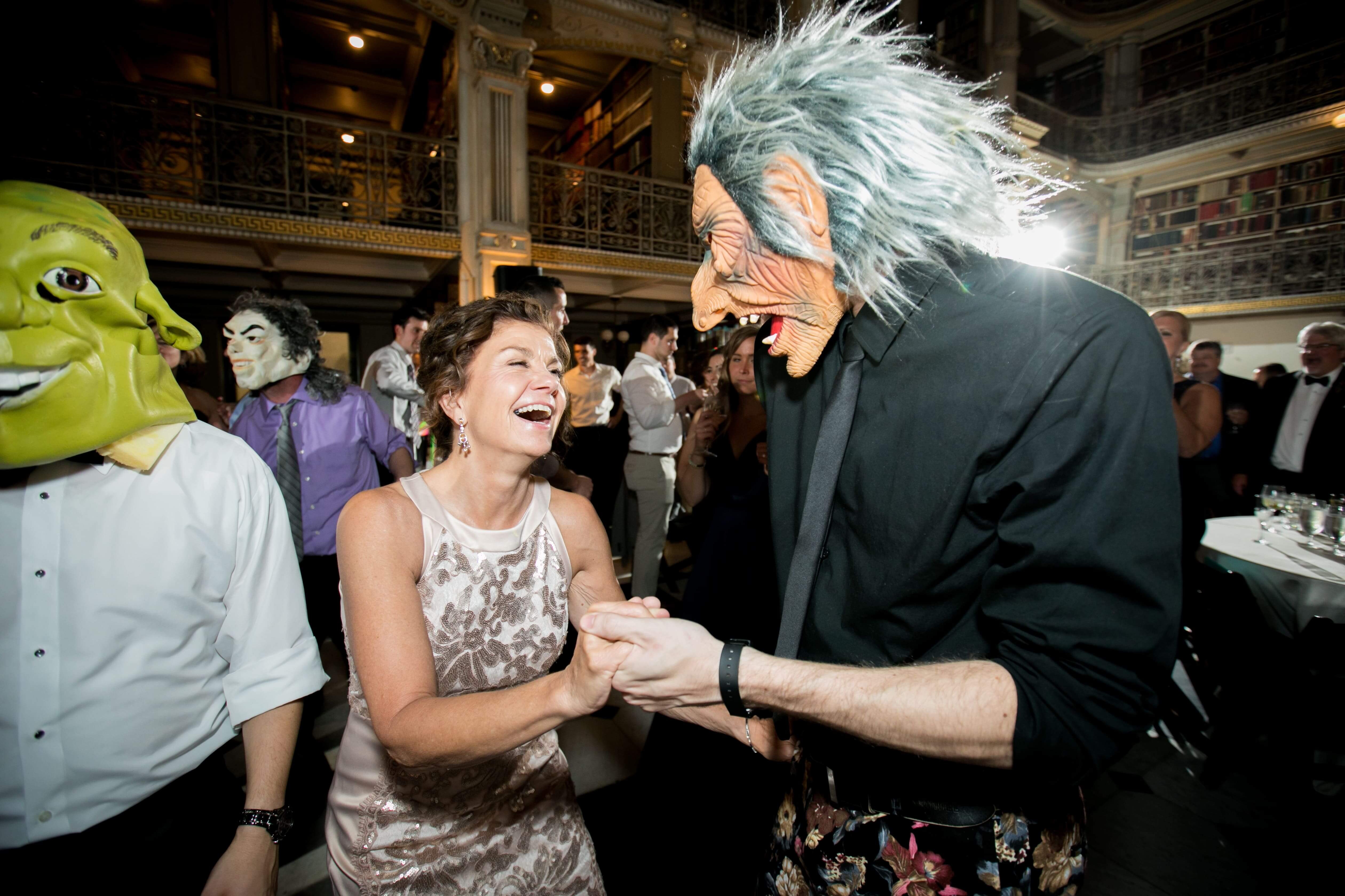 woman dancing with man in halloween mask at wedding