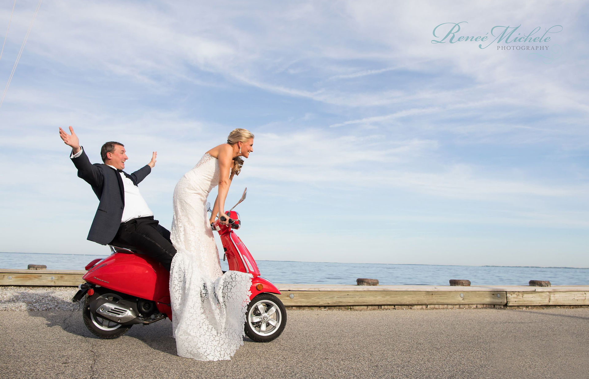 Bride and groom riding a red scooter