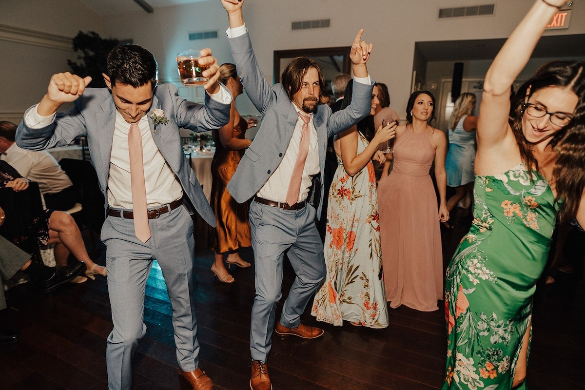 groomsmen dancing with guests at wedding