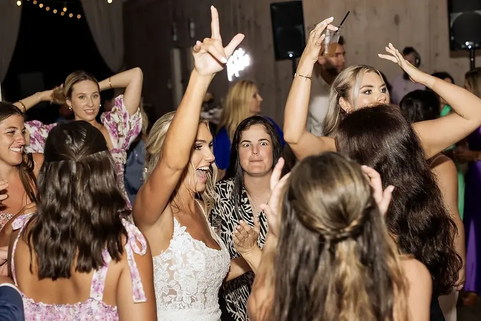 bride dancing with hand up with women