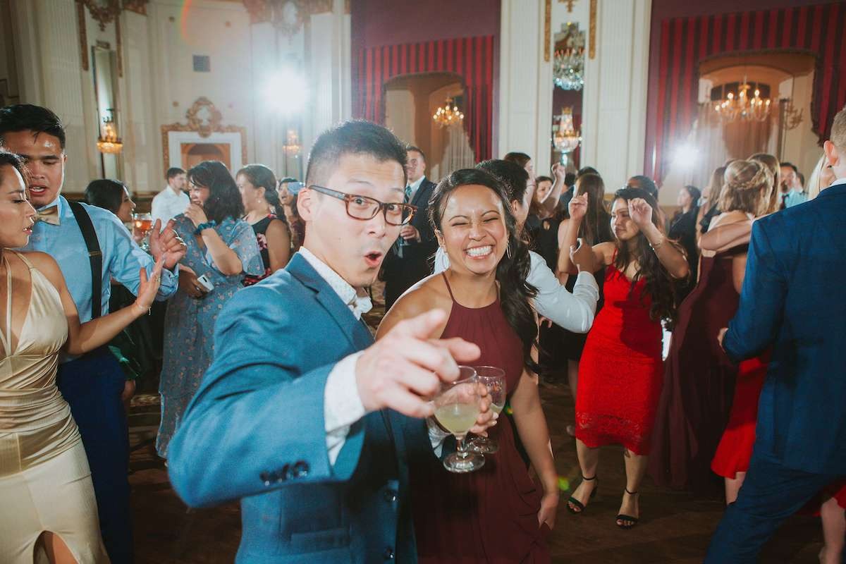 guy and woman dance and smile at wedding