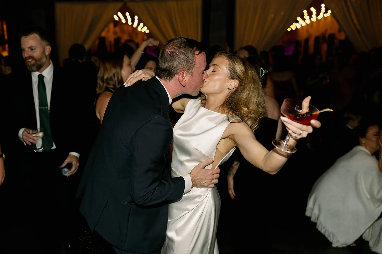 bride and groom kiss while dancing at wedding