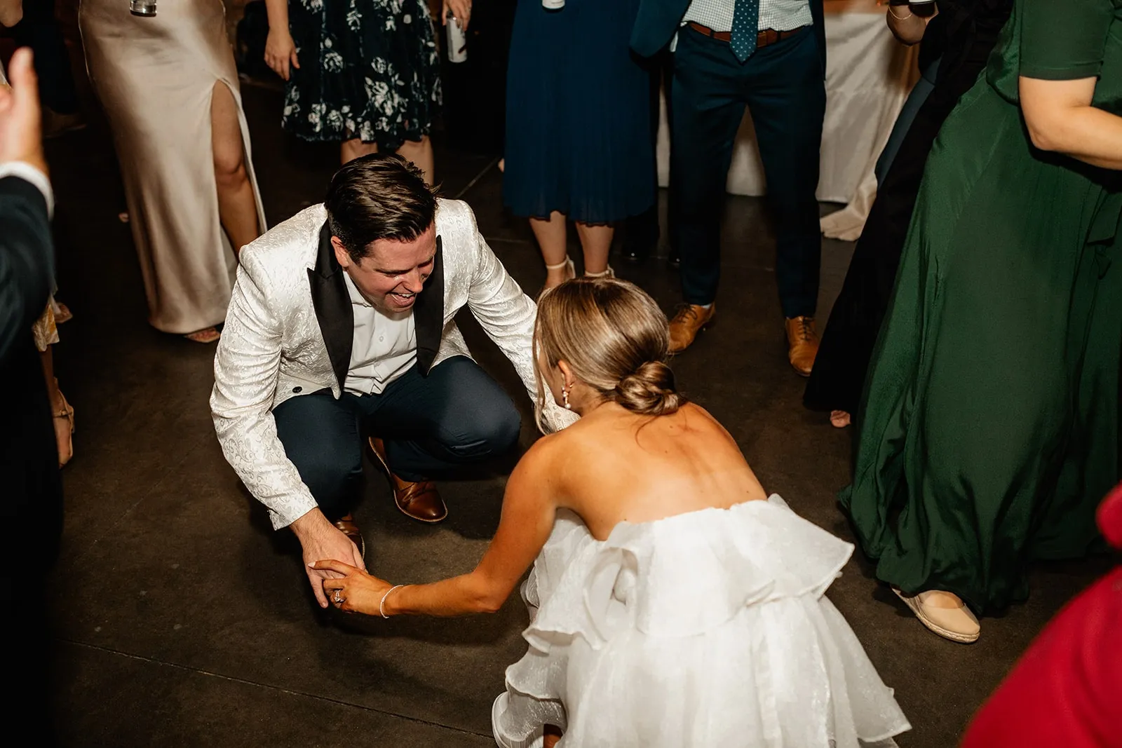 bride and groom holiding hands and dancing low to the floor