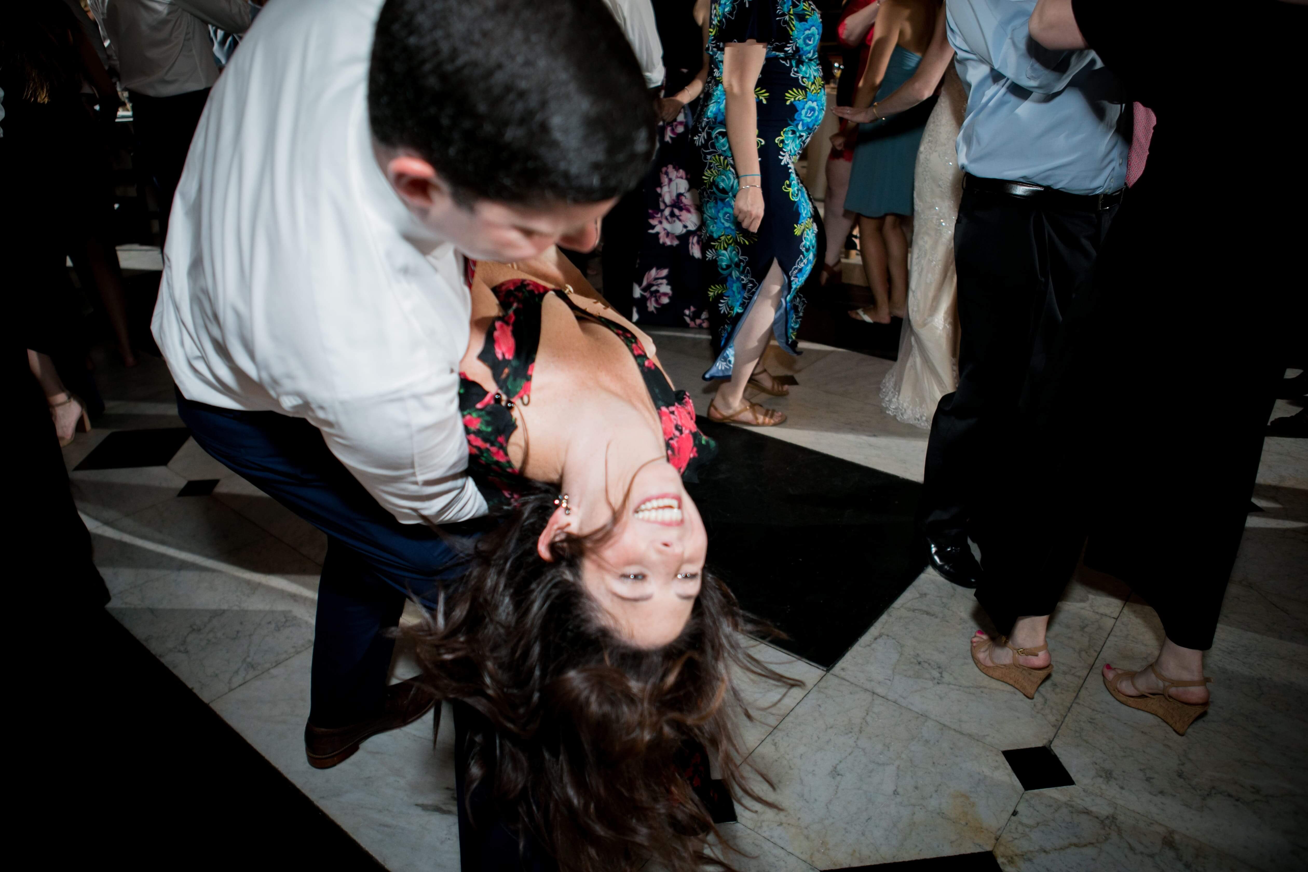woman being dipped on dance floor at wedding