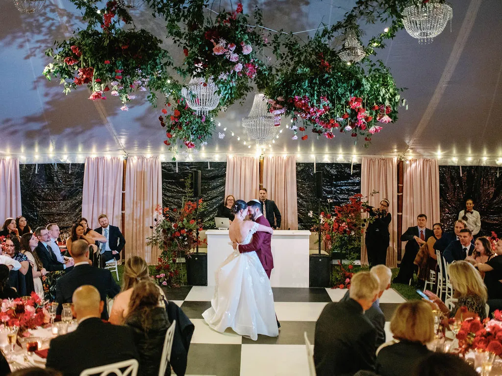 bride and groom dance while guests watch