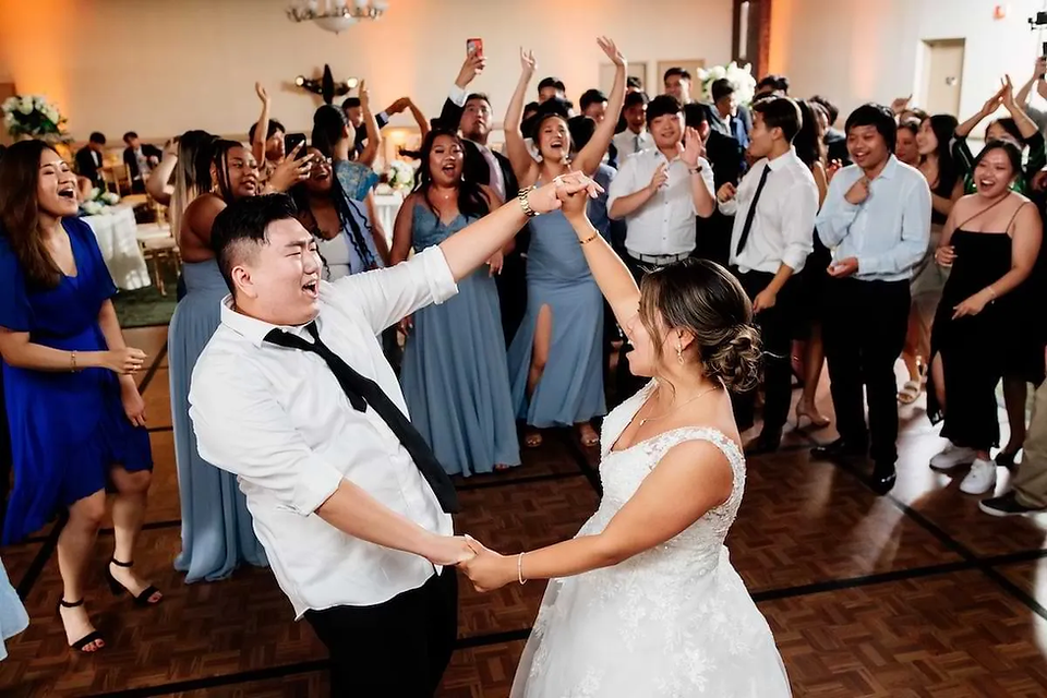 bride and groom dance while surrounded by guests