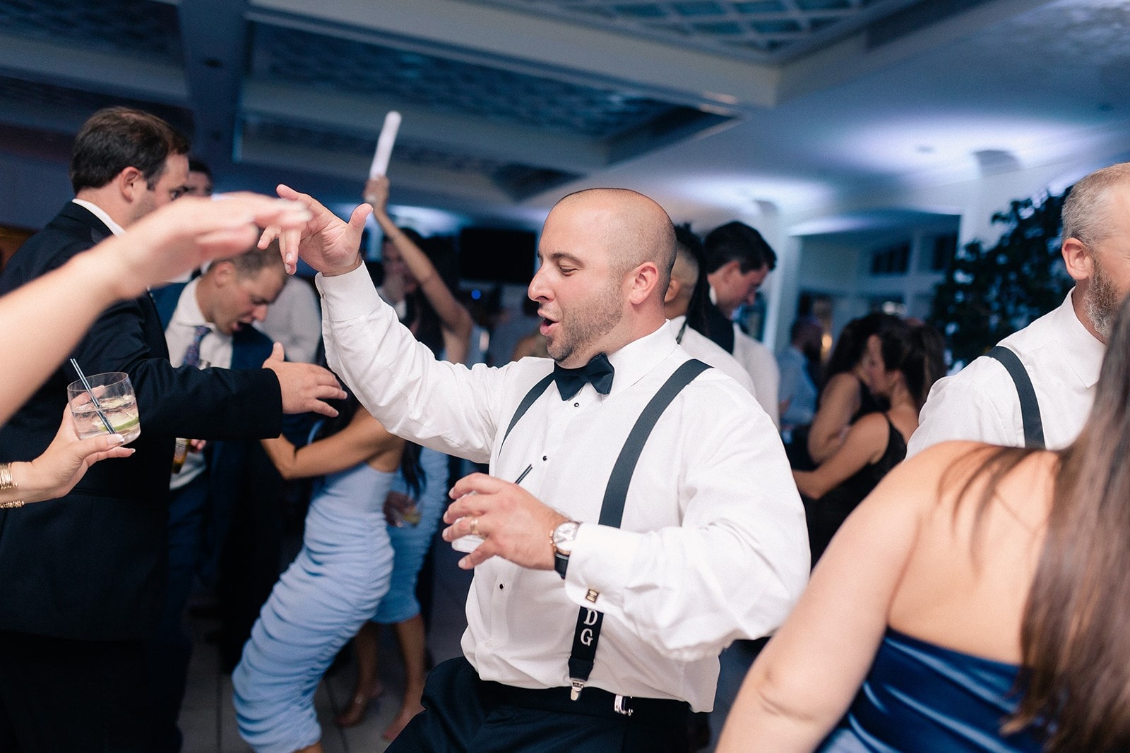 groomsman in suspenders dancing
