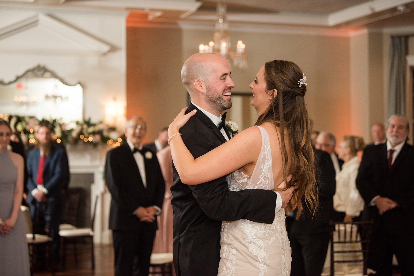 bride and groom dance while guests watch in the background