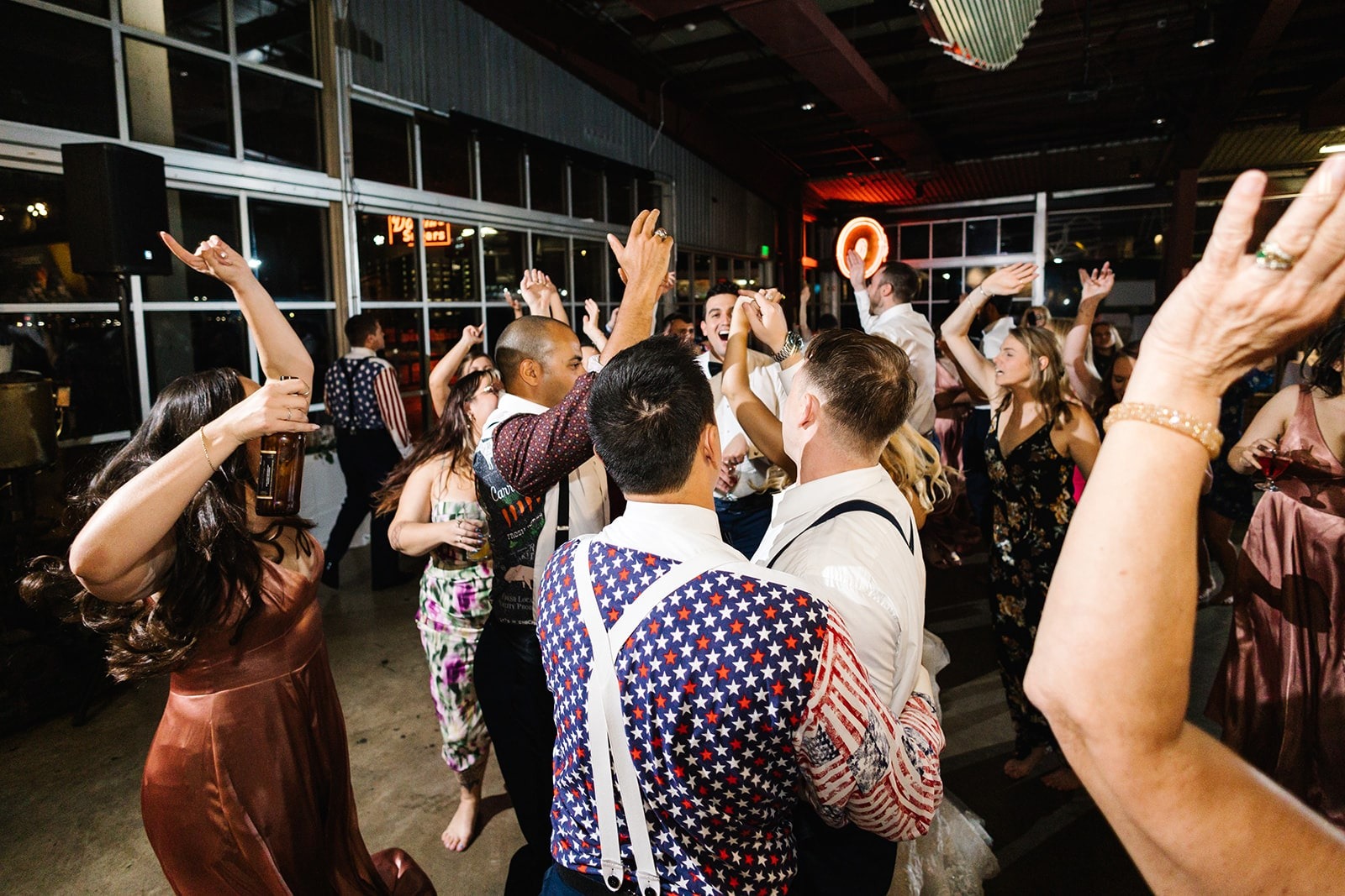 wedding guests dance with hands up