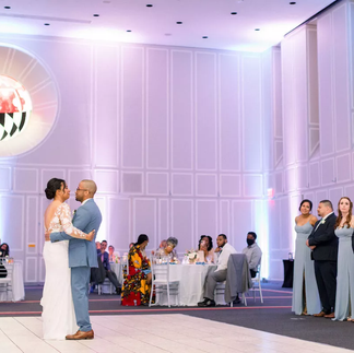 bride and groom first dance while guests watch