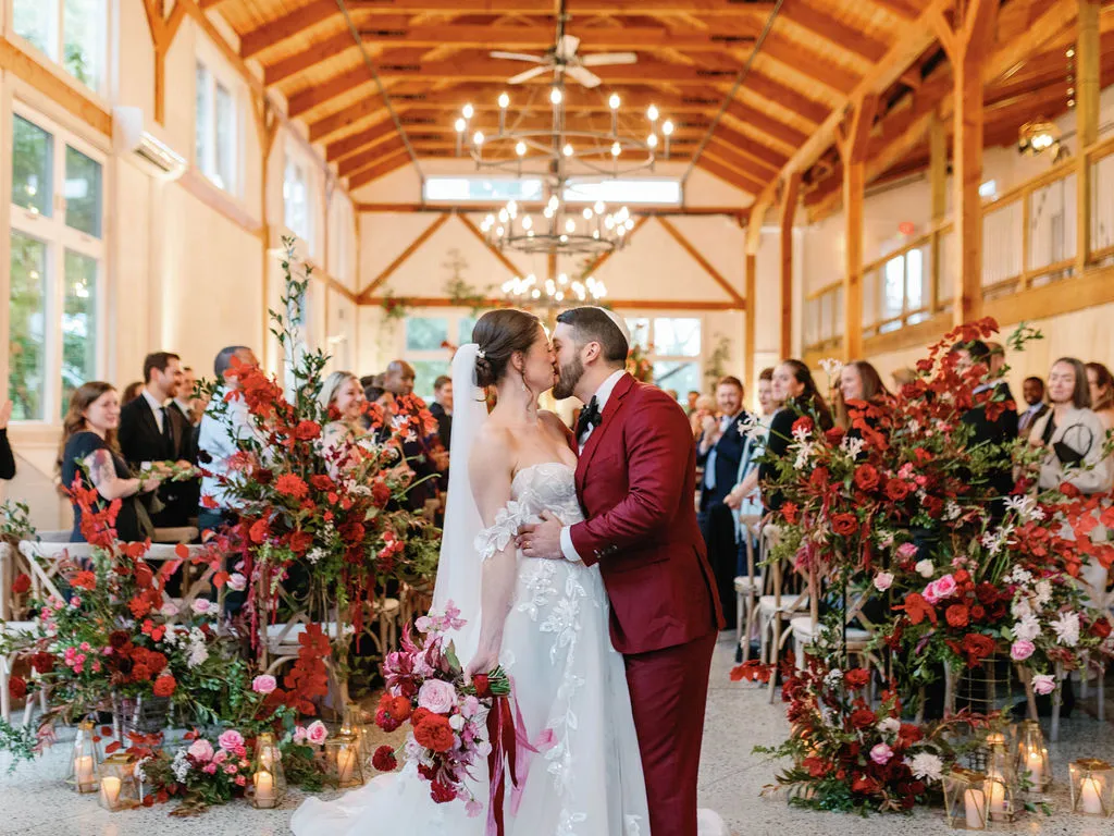 bride and groom kiss at the end of ceremony aisle