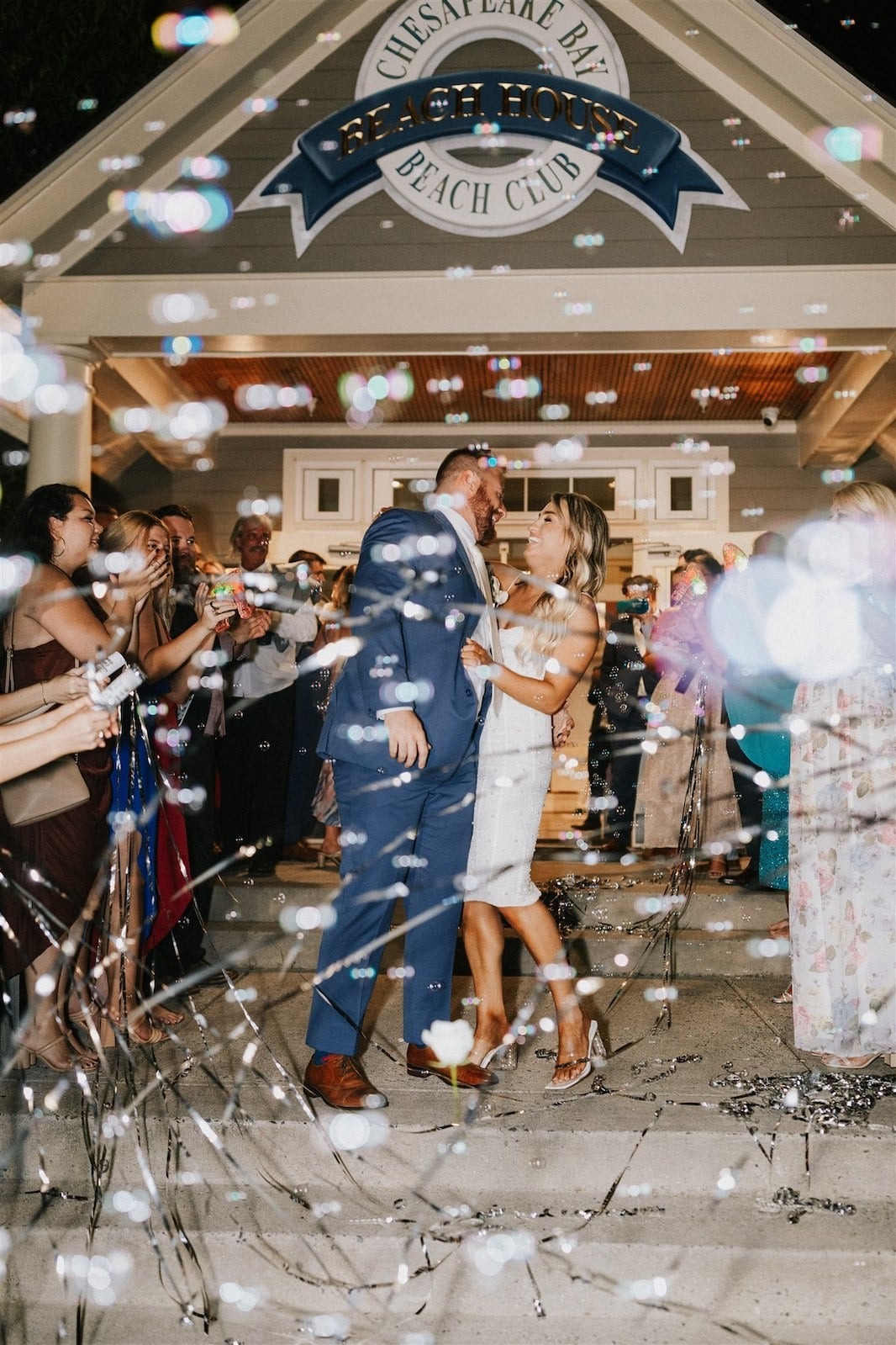 bride and groom kiss during streamer exit from wedding