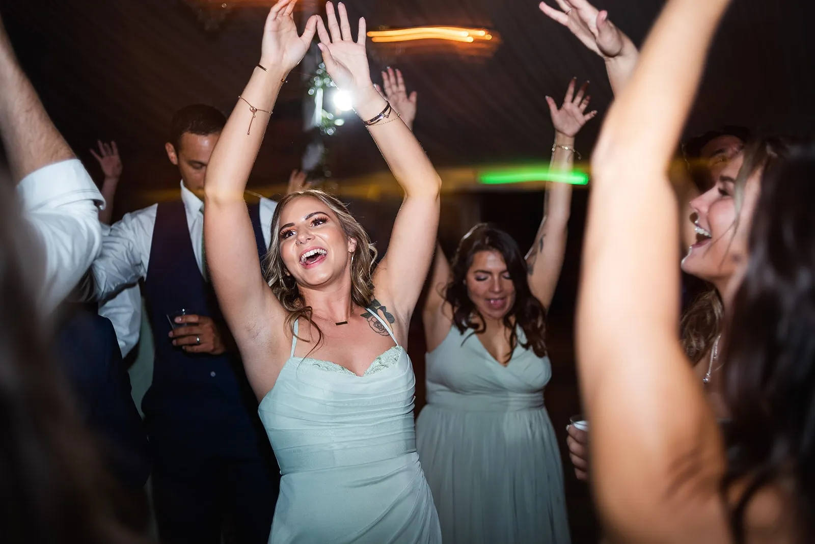 bridesmaids dancing with hands up and smiling