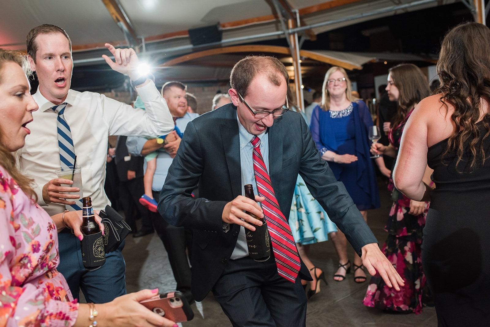 guy in red striped tie dancing at wedding