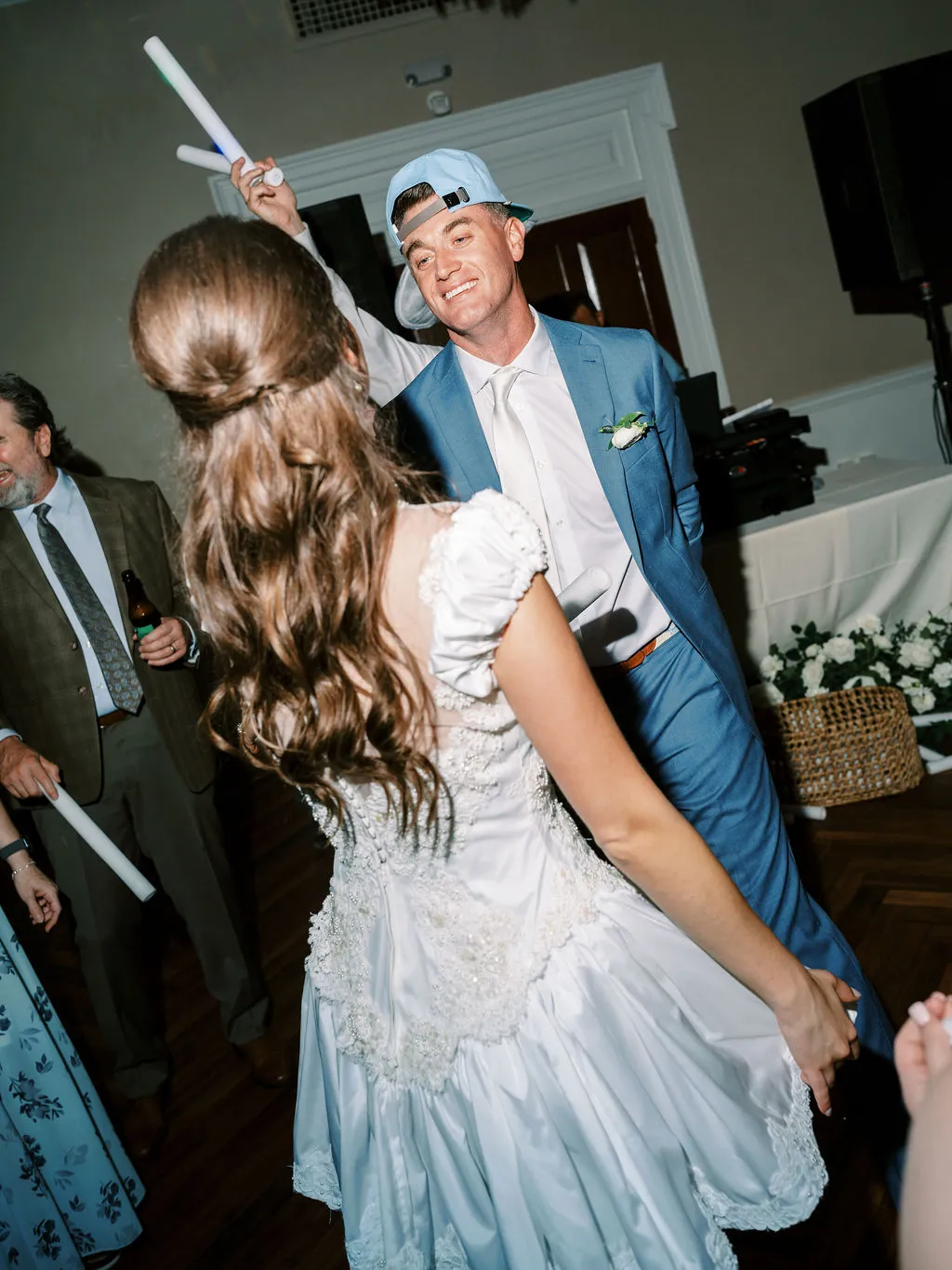 bride dancing with groom wearing a baseball cap backwards
