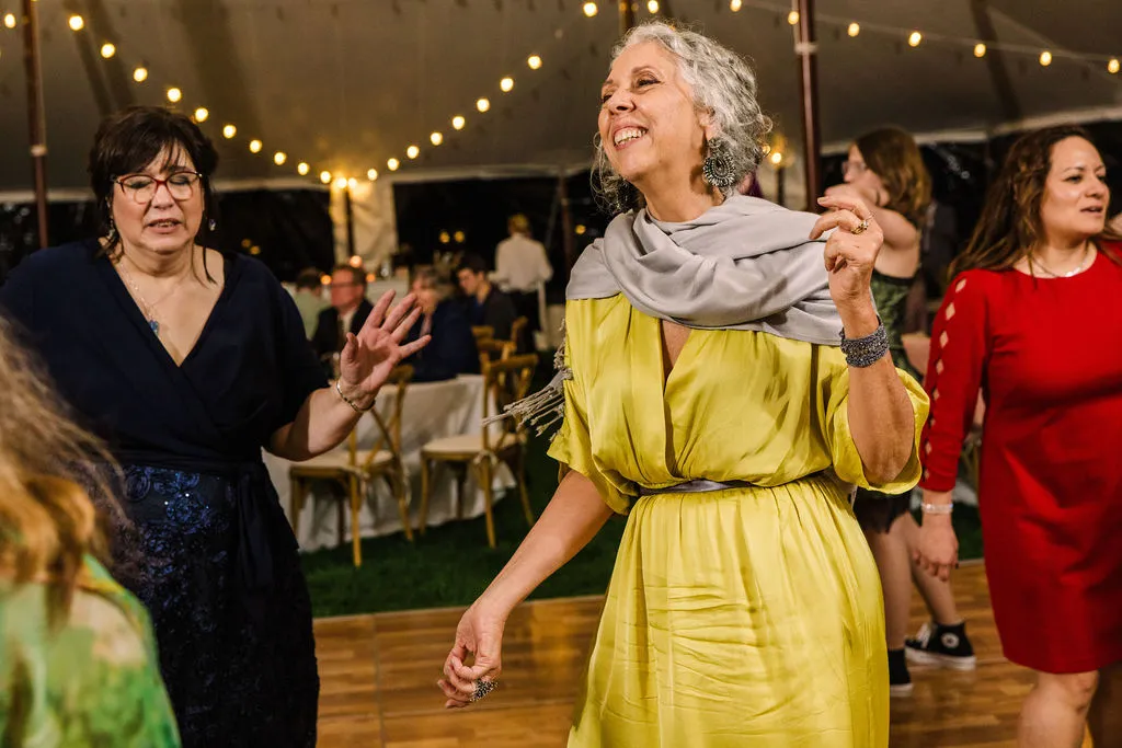 older woman in yellow dress dancing at wedding