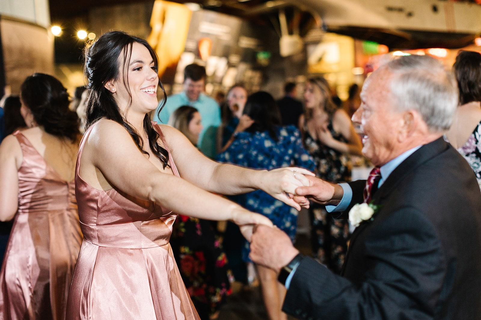 bridesmaid in pink dress dancing with older man in suit