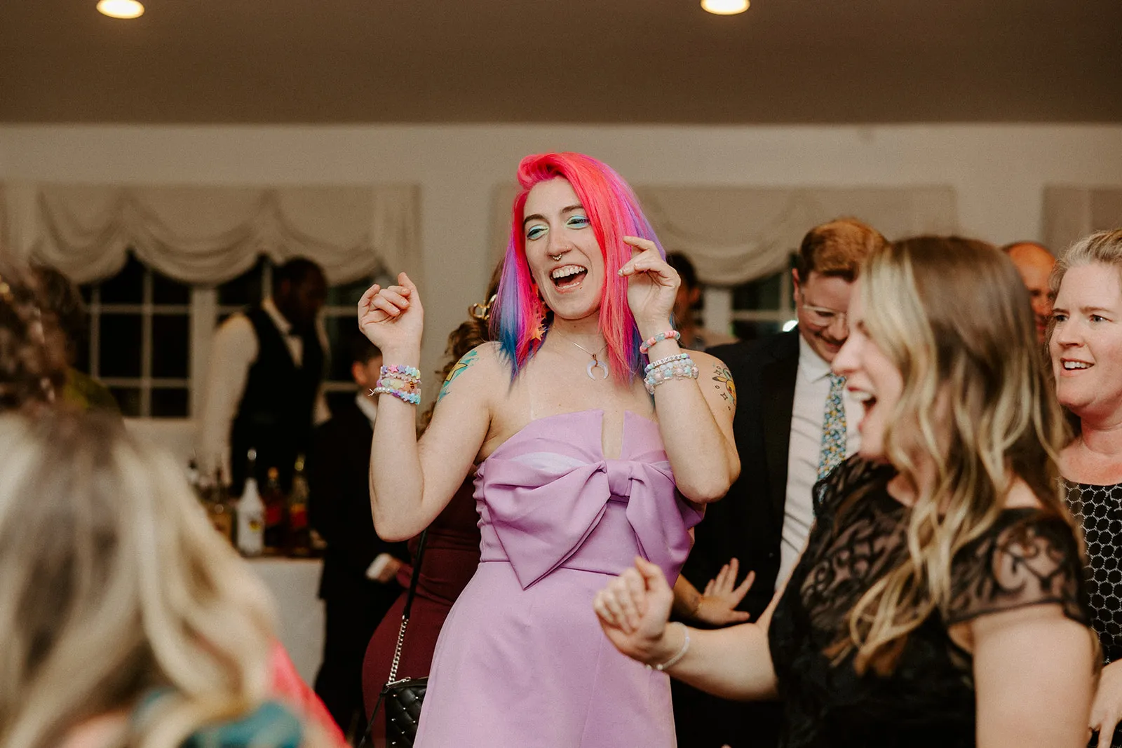 woman with pink hair dancing at wedding